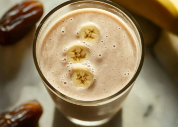 Delicious date and banana shake in a glass with a straw