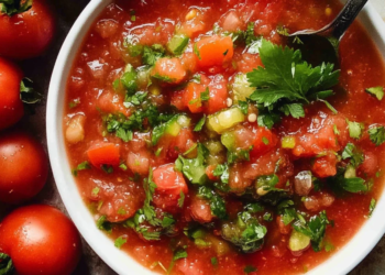 Bowl of vibrant homemade salsa made with fresh tomatoes, onions, and herbs.