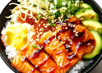 Delicious salmon rice bowl topped with fresh vegetables and sesame seeds