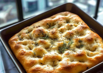 Homemade simple focaccia bread, golden brown with herbs and olive oil toppings