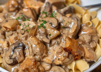 Delicious Chicken Stroganoff served with pasta and garnished with fresh herbs.